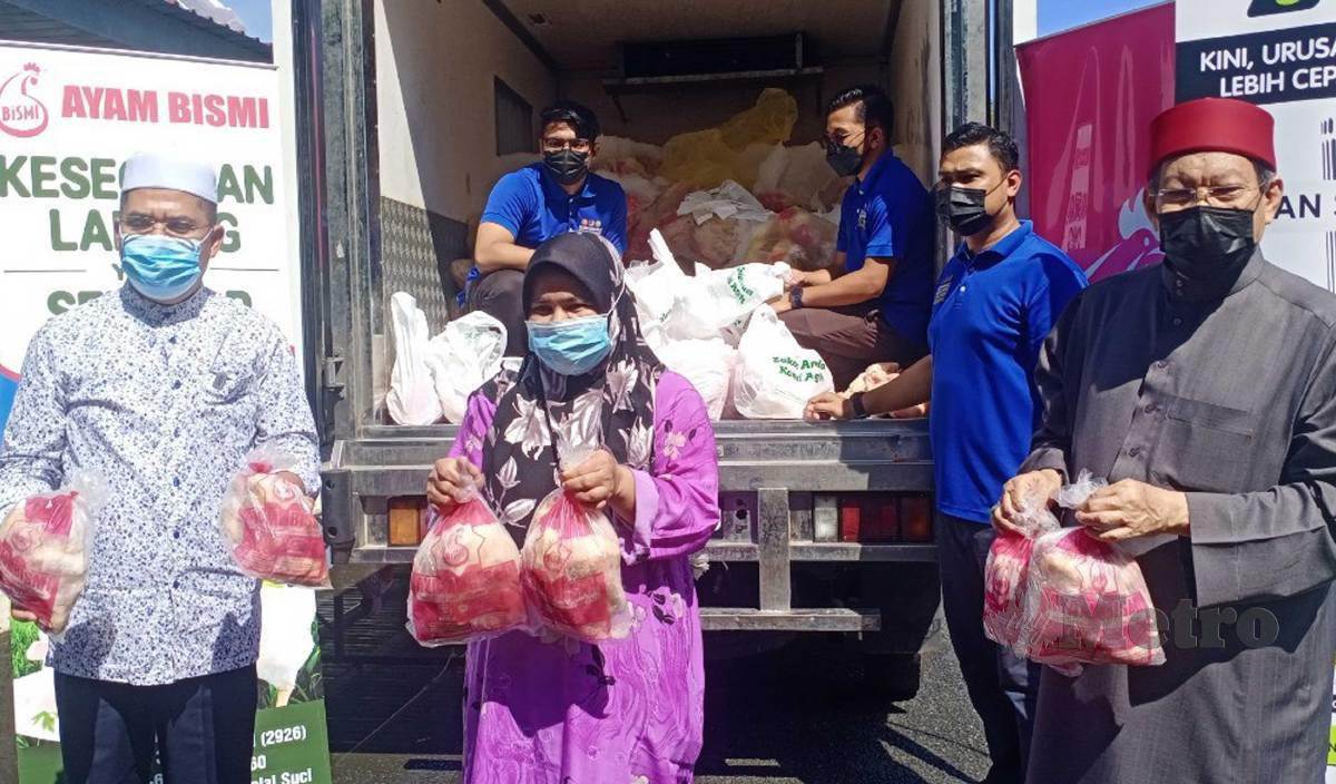 SYEIKH Fadzil (kanan) menyerahkan dua ekor ayam kepada asnaf di daerah Sik sempena Program Infak Aidilfitri LZNK di perkarangan Masjid Namek. FOTO Noorazura Abdul Rahman